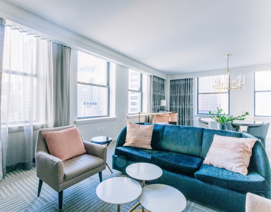 A naturally lit and open concept living room and dining area found in a suite at The Gwen