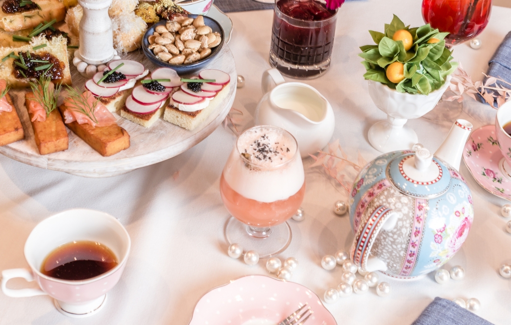 A table laid out with tea pots, fine china, and light snacks for the Tispy Tea Party at The Gwen.
