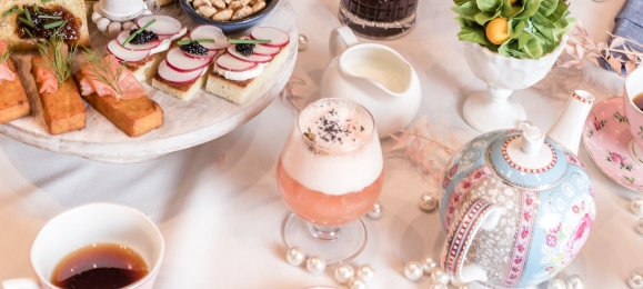 A table laid out with tea pots, fine china, and light snacks for the Tispy Tea Party at The Gwen.