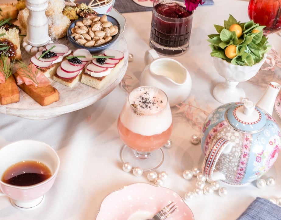A table laid out with tea pots, fine china, and light snacks for the Tispy Tea Party at The Gwen.