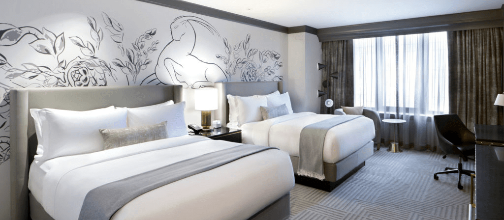 Two beds against a wall with line art of a deer