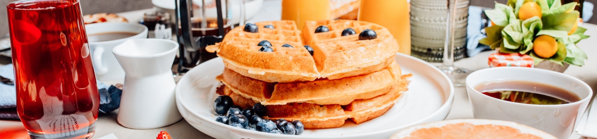 A weekend brunch served at The Gwen with a stack of blueberry waffles, fresh fruit and mimosas.