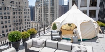 A tent setup for glamping on a balcony with a Chicago buildings in the background