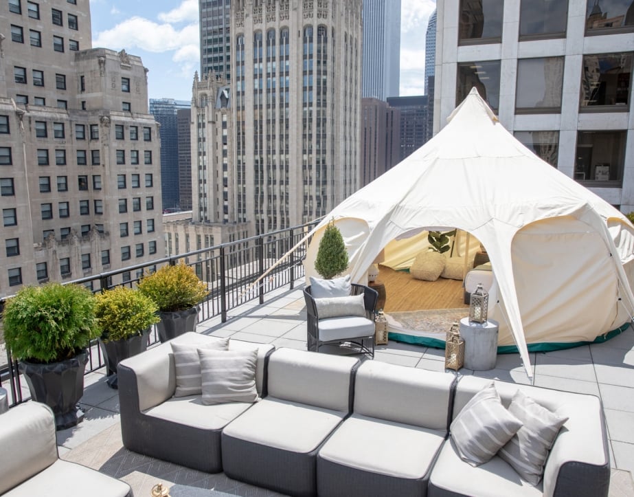 A tent setup for glamping on a balcony with a Chicago buildings in the background