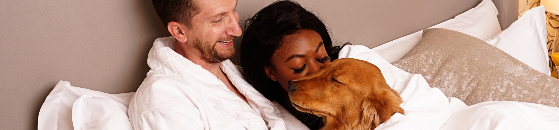 Couple with dog in bed