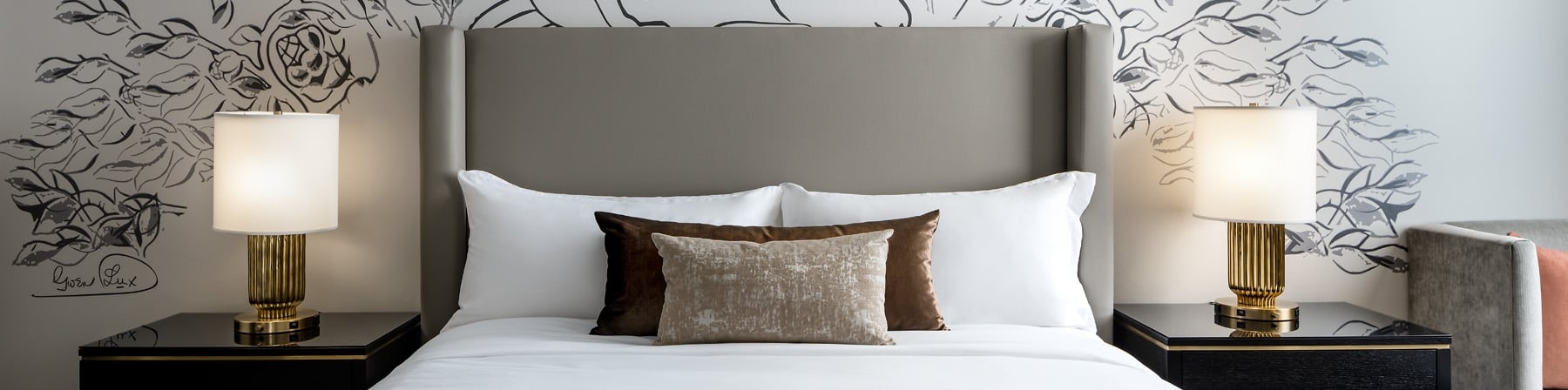 Straight on view of a bed and side tables with artwork on the wall