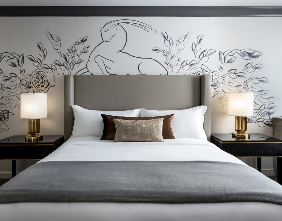 Straight on view of a bed and side tables with artwork on the wall