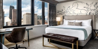 Bedroom with a large window showing off the Chicago cityscape