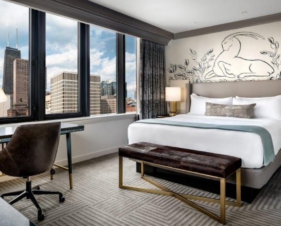 Bedroom with a large window showing off the Chicago cityscape