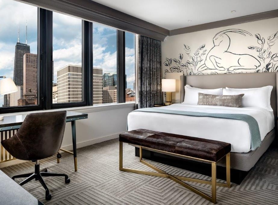 Bedroom with a large window showing off the Chicago cityscape
