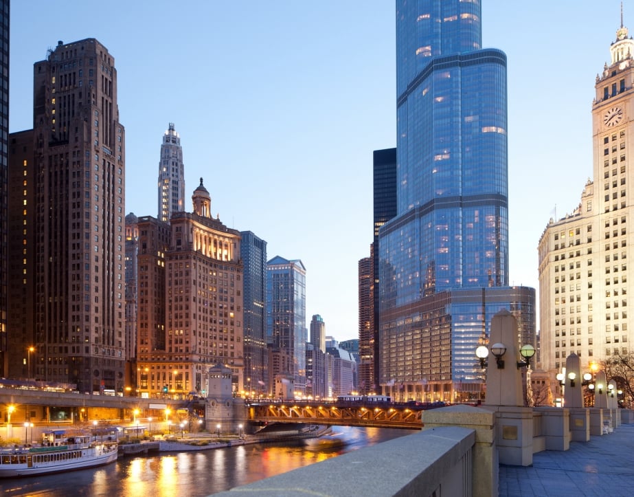 A view of the Chicago River and downtown buildings at dusk.