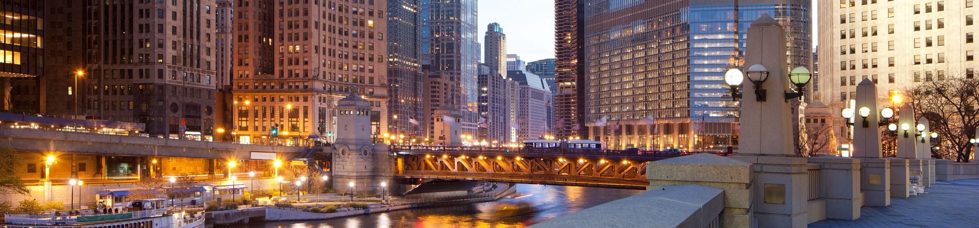 A view of the Chicago River and downtown buildings at dusk.