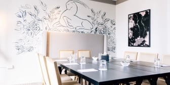 A meeting room with intricate wall art and a large table.