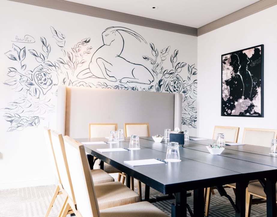 A meeting room with intricate wall art and a large table.