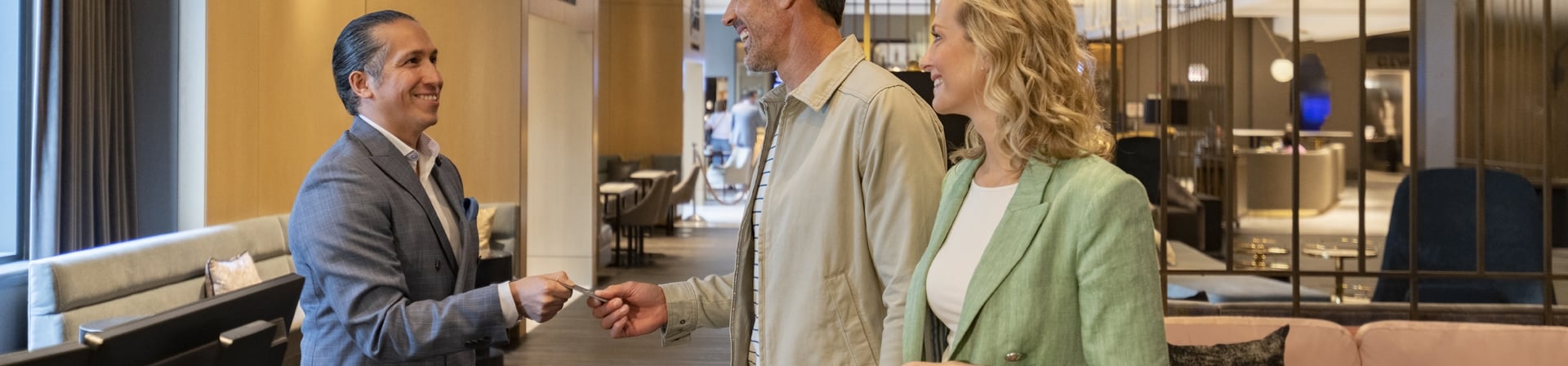A couple receiving their key from the concierge in the hotel lobby of The Gwen.