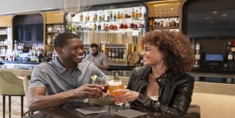 A couple smiling and enjoying drinks at Kostali in downtown Chicago.