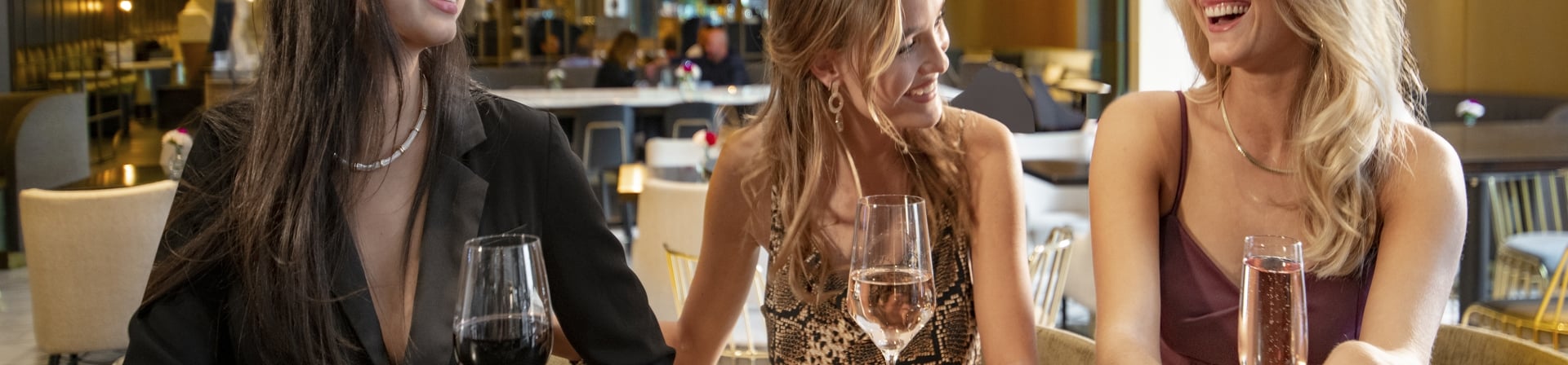 A group of friends enjoying drinks at the bar of hotel bar in The Gwen.