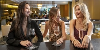 A group of friends enjoying drinks at the bar of hotel bar in The Gwen.