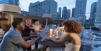 A group of friends enjoying drinks outside at Upstairs at The Gwen.