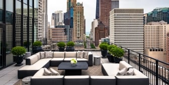 Comfortable outdoor seating and couches on a rooftop patio in downtown Chicago in The Gwen.