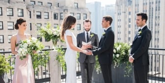 A bride and groom say their vows during their outdoor wedding on the sunny rooftop patio at The Gwen.