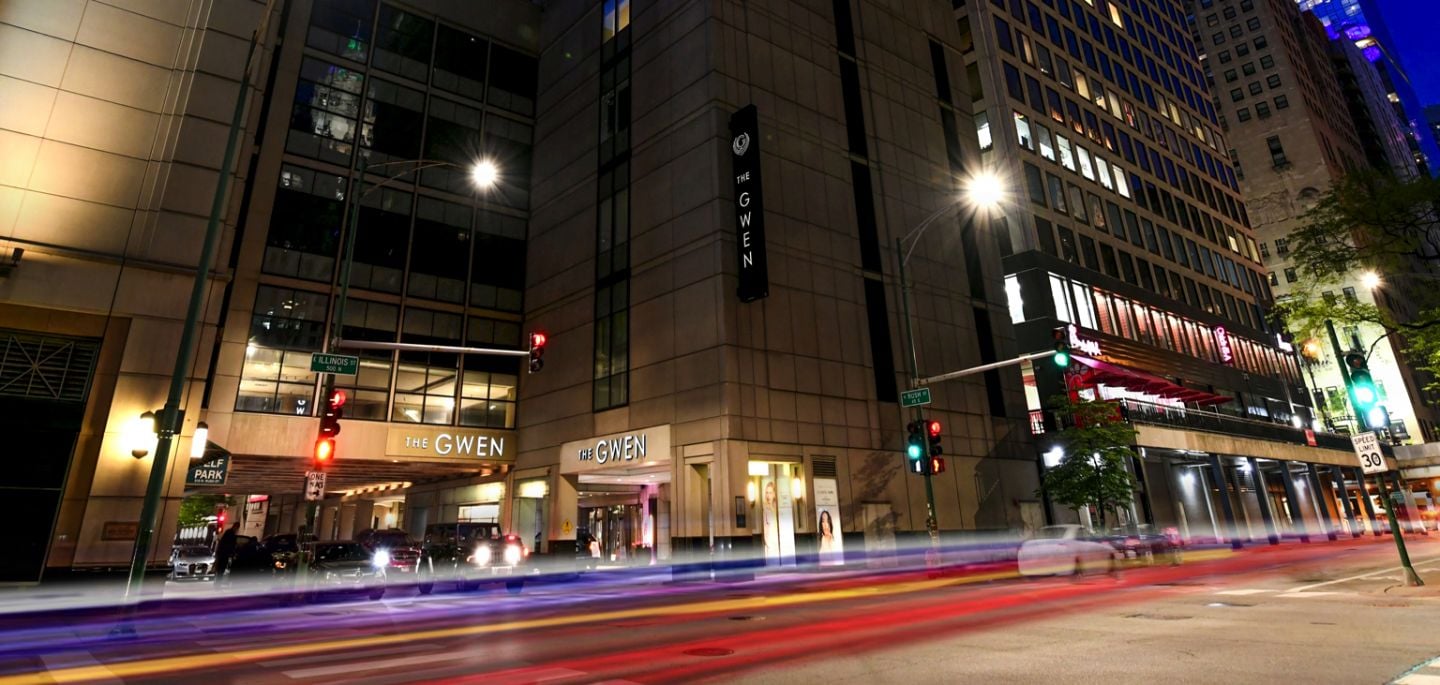 A view of The Gwen's exterior from the street at dusk.