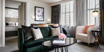 A green couch and small coffee table found in The Gwen's King Superior Suite