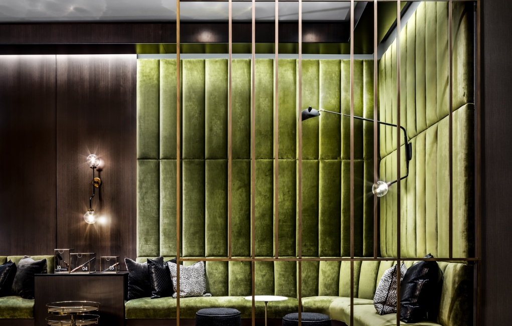 A large green sectional in the lobby of The Gwen.